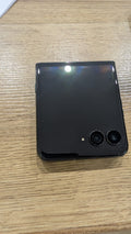 Motorola razr 60 Ultra chiuso, visto dal retro con il display esterno e le due fotocamere, su un tavolo di legno