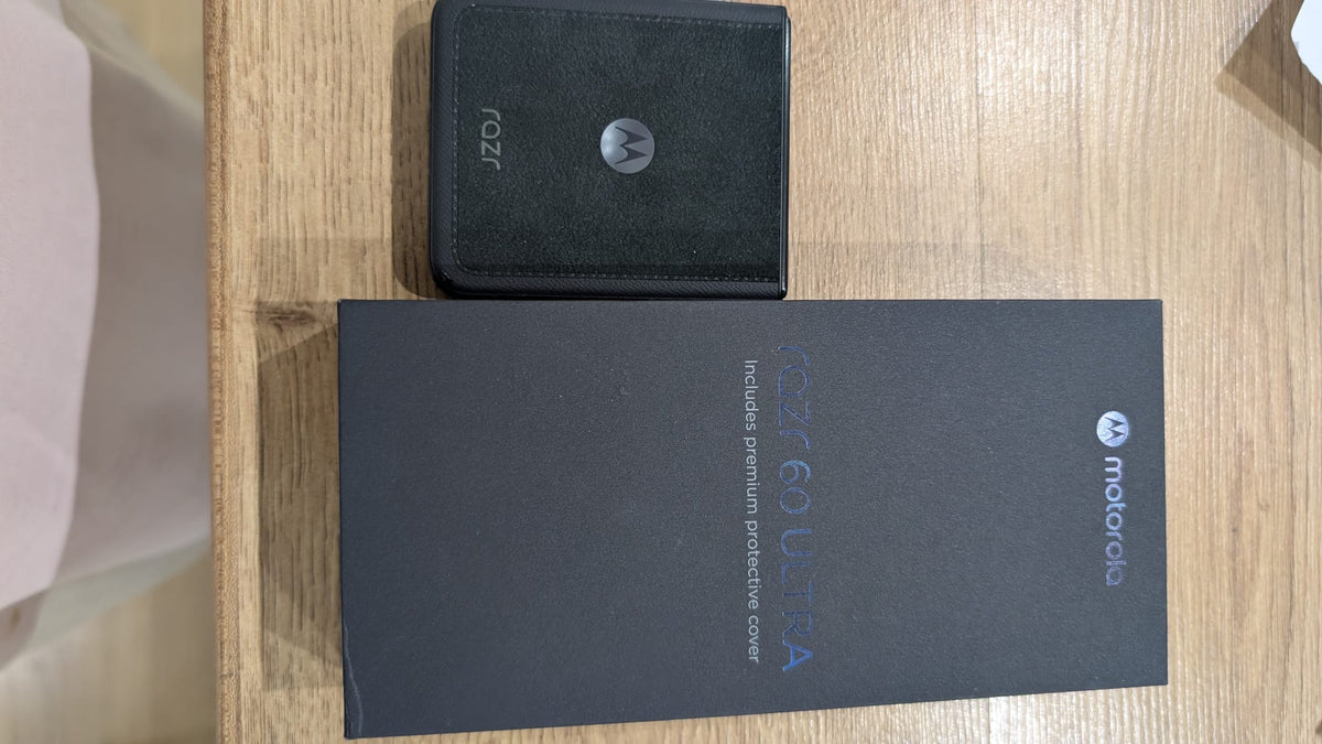 Motorola razr 60 Ultra con la cover premium nera, appoggiato sopra la scatola originale del telefono